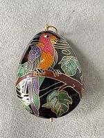 Front view of teardrop cloisonné pendant showing parrot and leaves