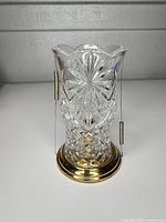 Full view of crystal candle holder on brass base with wire supports