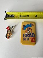 Front view showing both pins with tape measure for scale