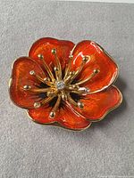 Front view showing enamel petals and rhinestones