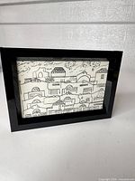Entire framed artwork showing black frame and cityscape drawing
