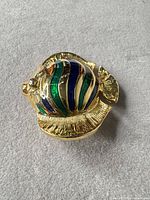 Front view of gold-tone fish brooch showing enamel stripes and overall shape