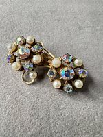 Front view showing floral cluster design, rhinestones, faux pearls