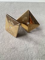 Front view of cufflinks showing pyramid-folded design and rhinestone accent