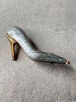Front view of silver enamel high-heel shoe brooch with rhinestones