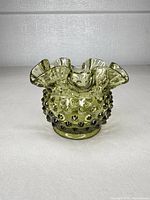 Front view of olive green hobnail glass vase showing overall shape and color