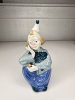 Front view of seated porcelain clown figurine