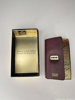 Key case beside open branded box interior text visible