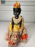 Front view of doll showing full dress, fruit hat, ring and overall condition
