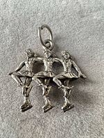 front view of pewter pendant showing three ice skaters detail