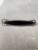Front view of sterling silver brooch with black onyx