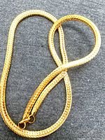 Close-up of necklace showing wheat weave pattern and jump ring clasp