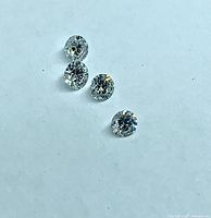 Four round brilliant cut diamonds on white background