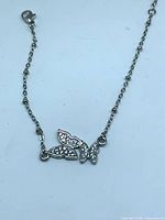 Full view of silver-tone chain with butterfly pendant and lobster clasp