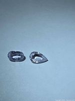 Oval and pear cut white sapphires on neutral background