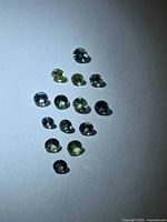 All fifteen round sapphires under light, showing color variation