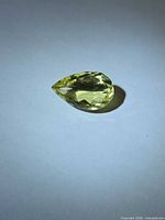 Pear-cut lemon citrine, face-up view on neutral background