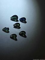 Six pear-cut multicolored sapphires on neutral background