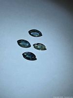 Four marquise sapphires in varied colours on white background