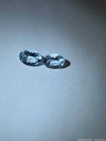 Both oval aquamarines side by side under directional light