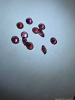 Group of faceted pink-purple garnets on white background