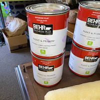 Front view of stacked BEHR paint cans on table