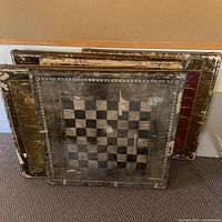 Stack of four folding card tables showing various painted tops