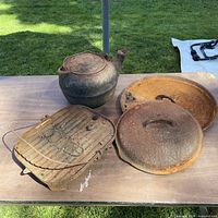 Tea kettle, two lids and grill displayed on table