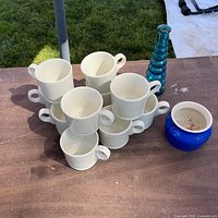 Group shot showing all eight Hall coffee cups, blue glass vase, cobalt pot on tabletop