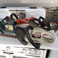 Group shot of all four hedge trimmers showing brands, handles and blades