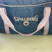Blue nylon duffle bag with Spalding logo, handles visible