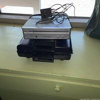 Silver TruTech DVD player stacked on black Dazey grill showing overall lot