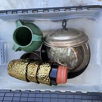 overview of bin showing green jug, three hammered metal planters, terracotta pot, silver covered dish
