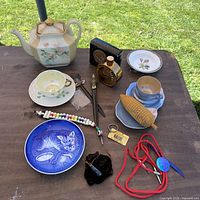 Full view of teapot, plates, cups, perfume bottles, accessories on table