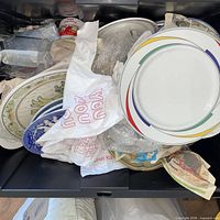 Overview showing assorted plates, mug and platter in tote