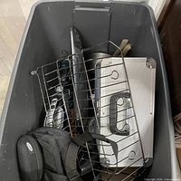 Overview of items in bin including dish rack, metal case, bag