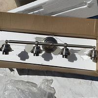 Fixture in foam packaging, showing brushed nickel bar and lamp holders