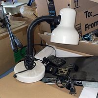 Full view of white desk lamp showing shade, black gooseneck and white base