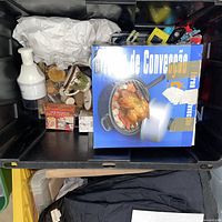 Overview of tote showing boxed cooker, spray bottle and assorted items