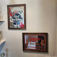 Both framed bar mirrors hung on wall