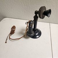 Full view of telephone lying on side showing base, stem, handset and cord