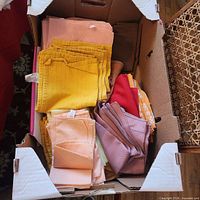 open box showing stacks of multicolored cloth napkins