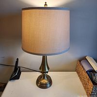 Front view of brass table lamp with shade on desk