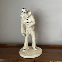 Full front view of cast concrete Pierrot clown on base