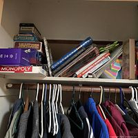 Upper closet shelf with visible board game boxes including Monopoly and Yahtzee
