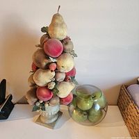 Front view of fruit topiary beside glass bowl with faux apples