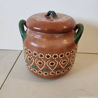 Front view of lidded pot showing design and handles