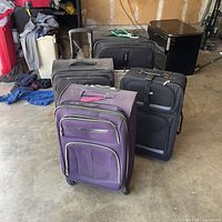 Group view of four rolling suitcases showing colors and general design