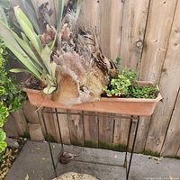 Front view showing metal stand and planter with plants