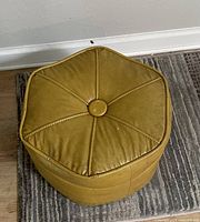 Top view of hexagonal mustard yellow ottoman showing button tuft and stitched panels